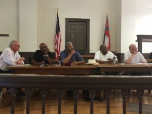 Panel discussing the death of Emmett Till and the subsequent murder trial. The two men in front of the American flag are Emmett Till's cousins. They were in there when Till was kidnapped.
